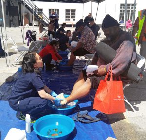Robert Lee gets his feet washed by an AUHS student at the annual Lamp Unto My Feet event on Thursday, April 13, 2017.
